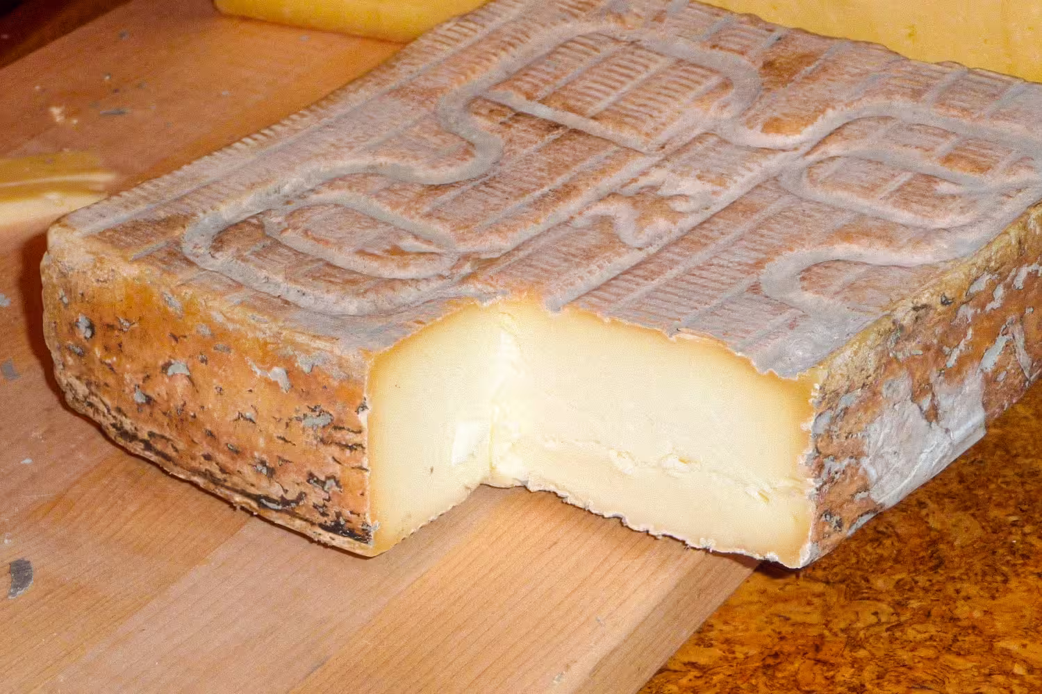 Forma di Taleggio DOP tagliata su un tagliere di legno